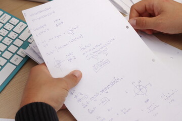 male hand writing on a paper, mathematics on a sheet, studying math