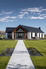 New home design featuring large windows, a modern structure, and a landscaped yard on a sunny day in an open countryside setting with distant hills