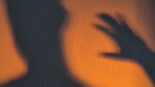 The shadow of the monster's hand reaching for the boy's head, close-up