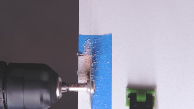 Close-up of a power tool drilling and creating a countersink hole in a wooden board
