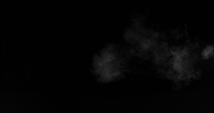 Super slow motion smoke effect of visible breath exhalation in icy conditions, filmed at 500 fps on a high-speed camera. Isolated on black background, ideal as realistic VFX overlay.