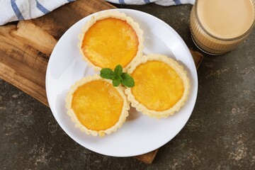 From Top View Three custard tarts arranged on a modern plate for dessert presentation, perfect for bakery and food concepts.