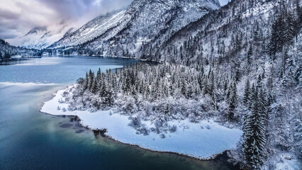 Winter magic in the Julian Alps. Lake Predil seen from above. Between snow and ice.