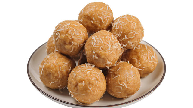 A plate of delicious sweet coconut ladoo indian dessert balls made with sweetened condensed milk and shredded coconut on white background