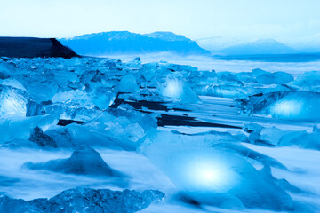 Big Chuck of Ice on Volcano sand beach in Iceland. Ice breaks off from the Iceberg in Iceland.