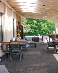 Outdoor seating area with modern furniture near green trees on a sunny day