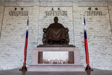 View of a bronze statue seated regally against a backdrop of marble, flanked by Taiwanese flags in Liberty Square, Taipei City, Taipei City, Taiwan.