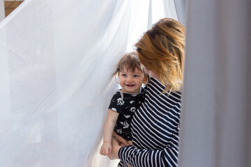Anonymous parent holding cute infant near window