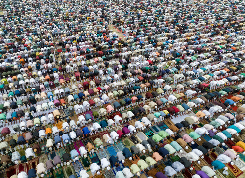 Aerial view of a multitude of people in prayer, their colorful mats creating a vibrant mosaic across the landscape, Dhaka, Dhaka Division, Bangladesh.