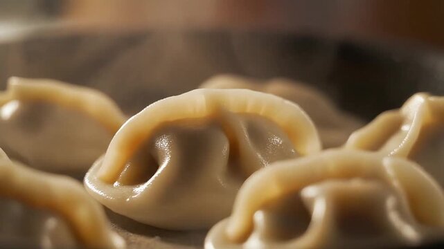 Dumpling skin turning glossy as steam rises around it with a smooth push in camera movement and warm light emphasizing texture and translucency