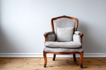 Ornate wooden armchair with light upholstery rests against a pale wall above a timber floor
