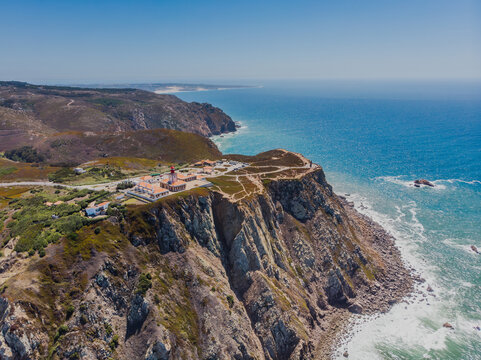 Aerial view of rugged cliffs meet the turquoise ocean at Cabo da Roca, Sintra, Portugal.