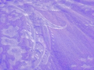 Abstract purple fabric texture with an elegant paisley pattern. Soft lavender textile background with organic flowing shapes and fine weave detail, perfect for fashion or luxury backdrops.