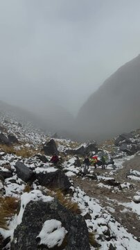 Hikers Trekking Through Snowy Mountain Pass