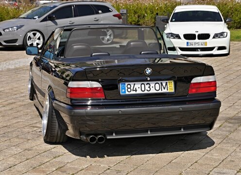 Rear view black BMW convertible parked on street