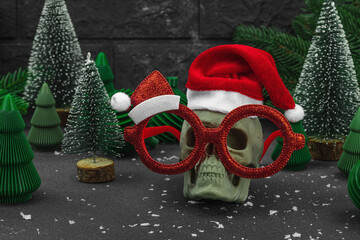 Creepy New Year concept. Handmade skull with traditional Santa Clause red hat. Christmas background