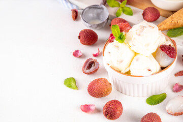 Tasty lychee sorbet ice cream. Lychee fruit gelato, in portioned bowl, on white pink background, with a lot of fresh lychees and waffle ice cream cones, copy space