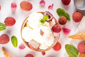 Tasty lychee sorbet ice cream. Lychee fruit gelato, in portioned bowl, on white pink background, with a lot of fresh lychees and waffle ice cream cones, copy space