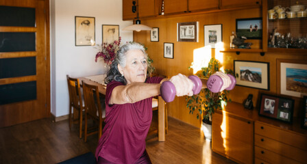 Active senior woman engaging in a home workout with dumbbells for healthy aging