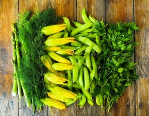 Spring greens lay on a wooden table. Asparagus, dill, and zucchini flowers make for a vegetarian...