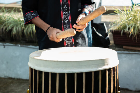 A traditional musician from the Maluku region of Indonesia plays a traditional percussion instrument, known locally as the Tifa.