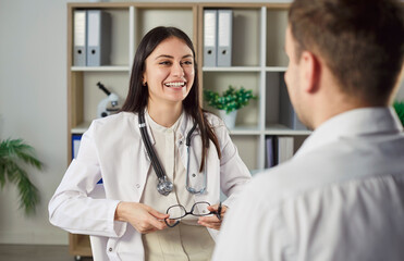 Positive doctor or nurse consulting patient during medical appointment in hospital, healthcare care...