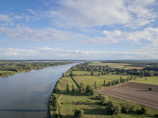 rural Normandy peaceful countryside waterway river Seine with farming fields and trees on either side. French farmland nature scene shot with drone for aerial view 