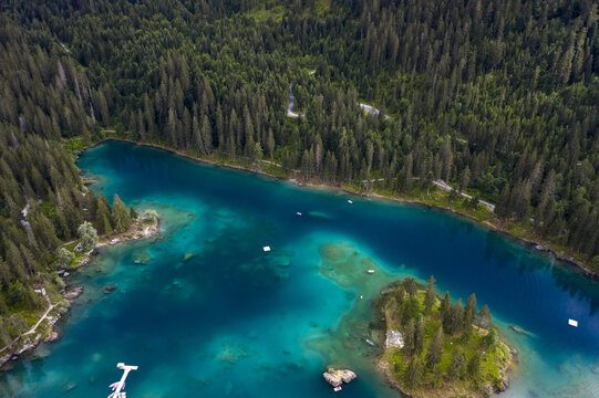 Aerial view of the serene turquoise waters of Caumasee lake surrounded by dense coniferous forests, a natural jewel nestled in the Swiss Alps, Flims, Grisons, Switzerland.