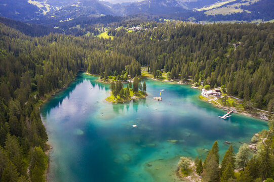 Aerial view of the turquoise waters of Lake Cauma surrounded by dark green forests, a tranquil oasis nestled amidst the Swiss Alps, Flims, Grisons, Switzerland.