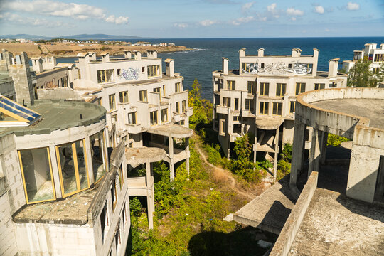 View of abandoned, unfinished buildings with graffiti against the backdrop of the blue sea and sky, hinting at decay and forgotten dreams, Costa del croco, Tsarevo, Bulgaria.