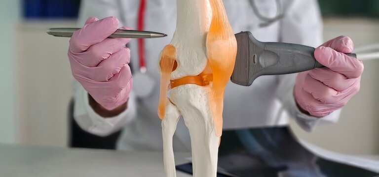 Doctor conducts ultrasound examination knee in clinic concept