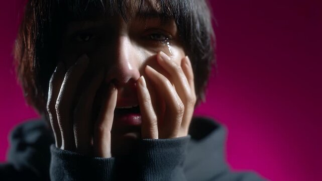 Close-up shots capture a person's emotional struggle as they cover their face with hands. The setting features dramatic lighting that enhances the mood and intensity of feelings expressed