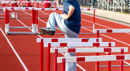 Young Athlete Practices Hurdles Drills on a Track