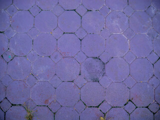 Full frame pattern and texture of interlocking hexagonal concrete pavers painted purple, abstract ground surface and urban walkway design.