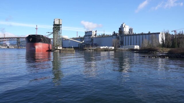 Freighter at Grain Terminal Vancouver 4K UHD.A freighter at a grain terminal on the shore of Burrard Inlet. The Iron Workers Memorial Bridge in the background. 4K UHD.
