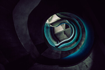 View of a winding staircase, a dark vortex of steps illuminated with an eerie blue glow, descending into the unknown, Crevarska Strana, Sisak-Moslavina County, Croatia.