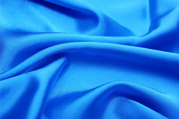 Vibrant blue satin fabric texture, shimmering silk folds, luxury textile background ideal for fashion, beauty branding, elegant design, packaging.