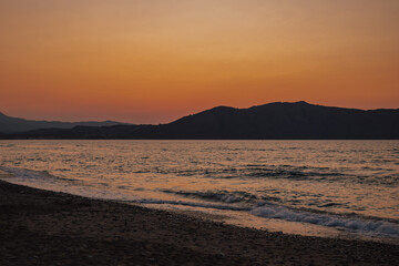 Golden mediterranean sunset over the calm sea and beach, inspiring tranquility