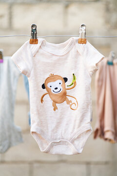 Illustrated baby bodysuit hanging on a clothesline