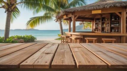 Fototapeta premium Empty wooden table top with blurred tropical beach bar, ocean, and palm trees in the background