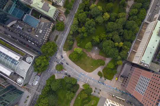 Aerial view of verdant trees contrasting with the sharp angles of modern buildings and roads, creating a dynamic urban tapestry, Frankfurt am Main, Hessen, Germany.