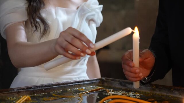 The bride and groom light candles in the church