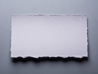 Torn white paper on gray background with ripped edges and shadow