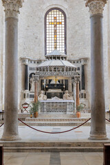 Bari, Italy. Ciborium above the main altar in the Basilica of San Nicola in Bari, featuring a stone canopy, columns and crucifix illuminated by soft light within the historic sanctuary. © Alessandro