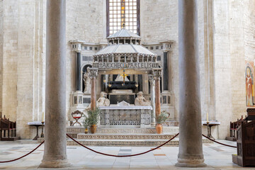 Bari, Italy. Wide view of the Ciborium above the main altar in the Basilica of San Nicola, featuring marble columns, statues and ornate sacred decorations in soft light. © Alessandro