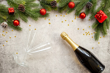 Christmas fir tree branch with champagne bottle and decoration, top view. Happy New Year greeting card