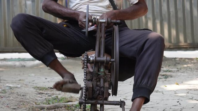 person using pedal operated grinding machine to sharpen a knife