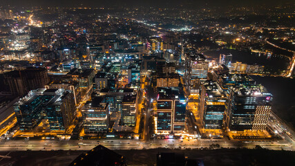 Aerial view of the gleaming cityscape, where warm lights flicker against the dark canvas of night, illuminating the modern architecture, Hyderabad, Telangana, India.