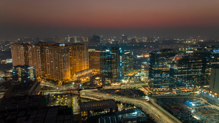 Aerial view of gleaming skyscrapers reflecting the vibrant city lights against the twilight sky, showcasing Hyderabad's modern architecture, Hyderabad, Telangana, India.