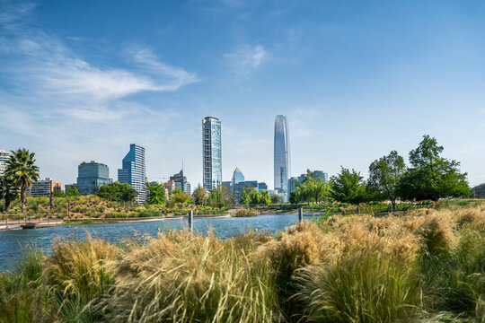 Der Parque Bicentenario Park mitten in Santiago de Chile mit Blick auf die Skyline mit modernen Hochh&auml;usern, im Vordergrund ein See